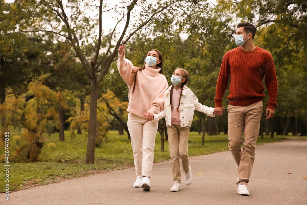 Lovely family walking together in park during coronavirus pandemic