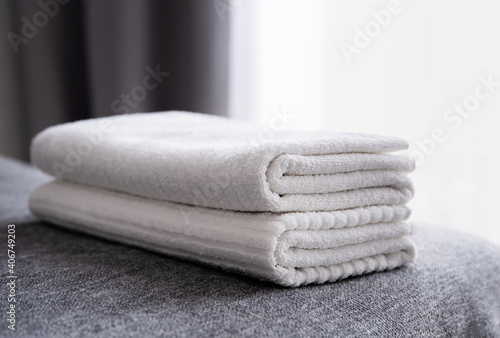 Hotel staff, fresh white bath towels on the bed. Room cleaning service.