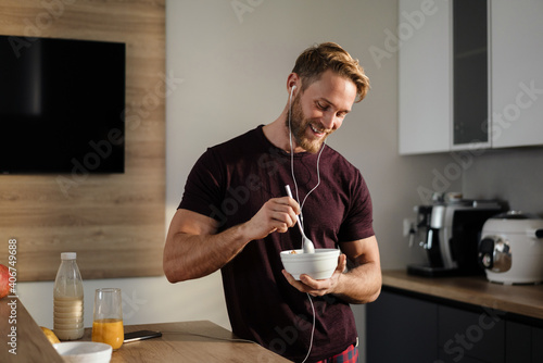 Attractive healthy young man having tasty breakfast photo