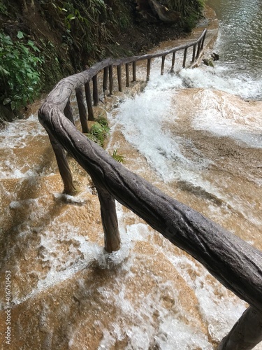 stairway beside watfall and wood banisters 