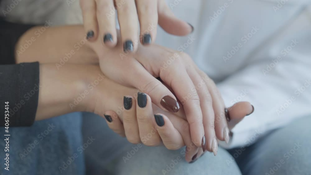 Close-up of female Caucasian hand caressing palm of young woman. Loving lesbians holding hands sitting indoors. Unrecognizable friends supporting each other. Close-up of female Caucasian hand caressing palm of young woman. Loving lesbians holding hands sitting indoors. Unrecognizable friends supporting each other.