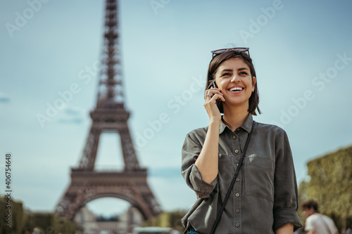 Photography Young urban business woman talking on phone in Paris France next to Eiffel Tower