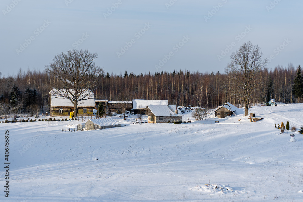 in winter a lonely old country house located in a valley surrounded by forest and has snow