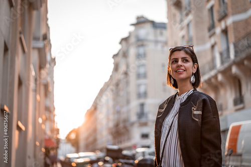 Beautiful young female tourist in city of Paris France enjoying holidays in beautiful little street festival and using phone photo