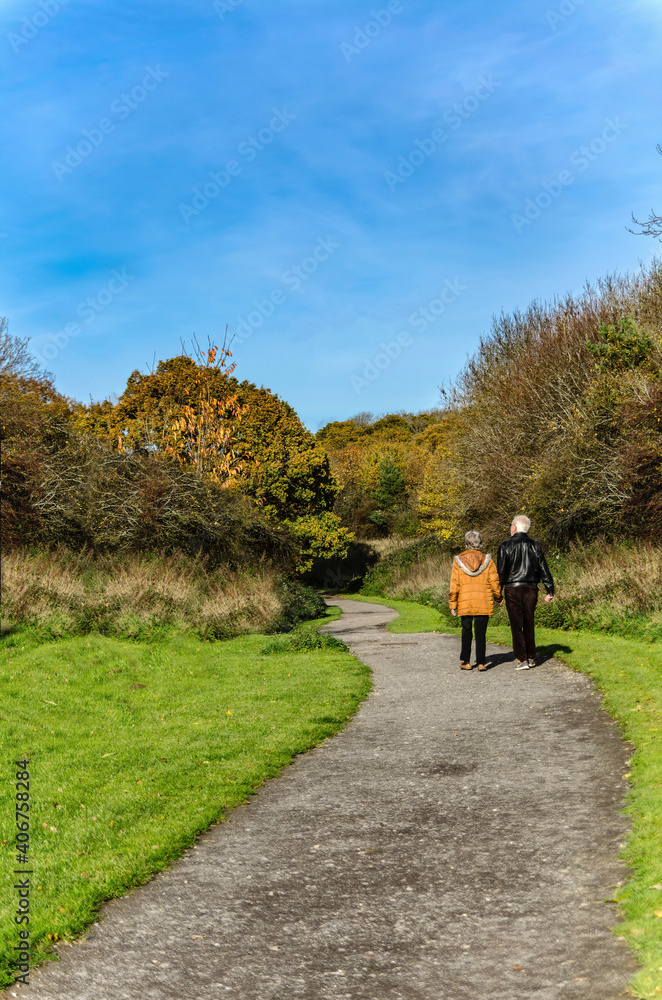 old couple walking down path 
