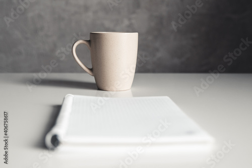 Office desk table with supplies, coffee cup and flower. Top view