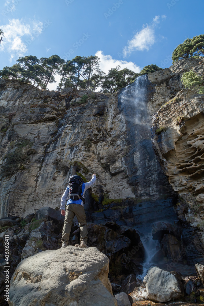 Male hiker standing on a rock near a waterfall in the Iztaccihuatl Mountain in Mexico