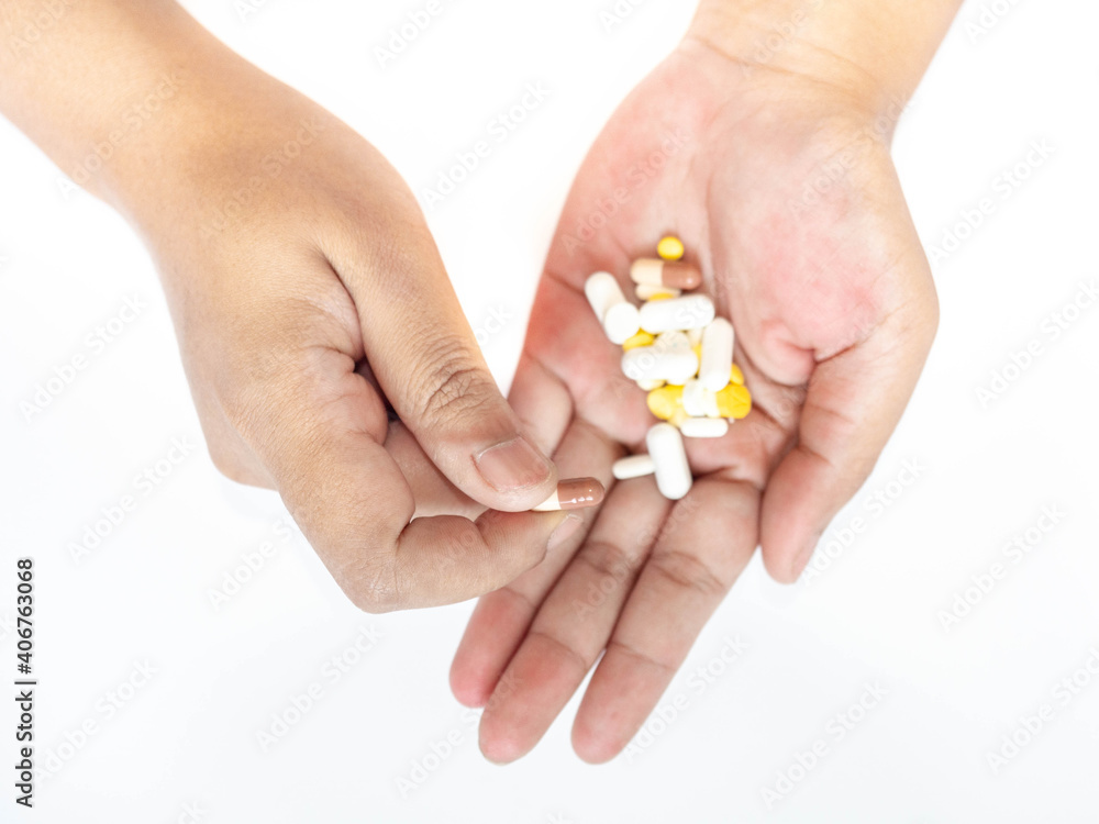 A woman picks up a pill from her hand White background. A woman picks up a pill from her hand White background.