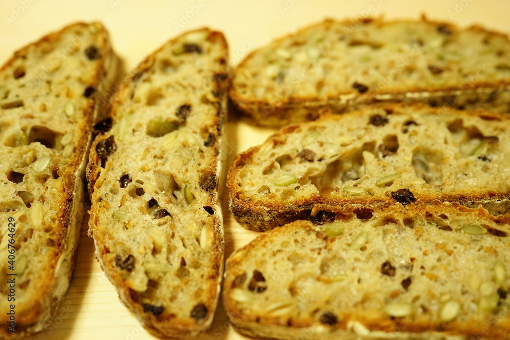 Sliced Artisan Bread with Raison and Nuts on cutting board - レーズン ナッツ パン カンパーニュ	スライス