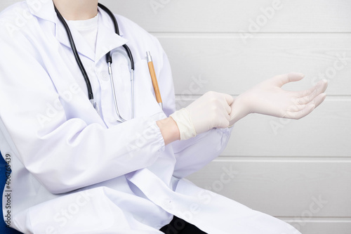 doctor putting on rubber gloves before vaccination