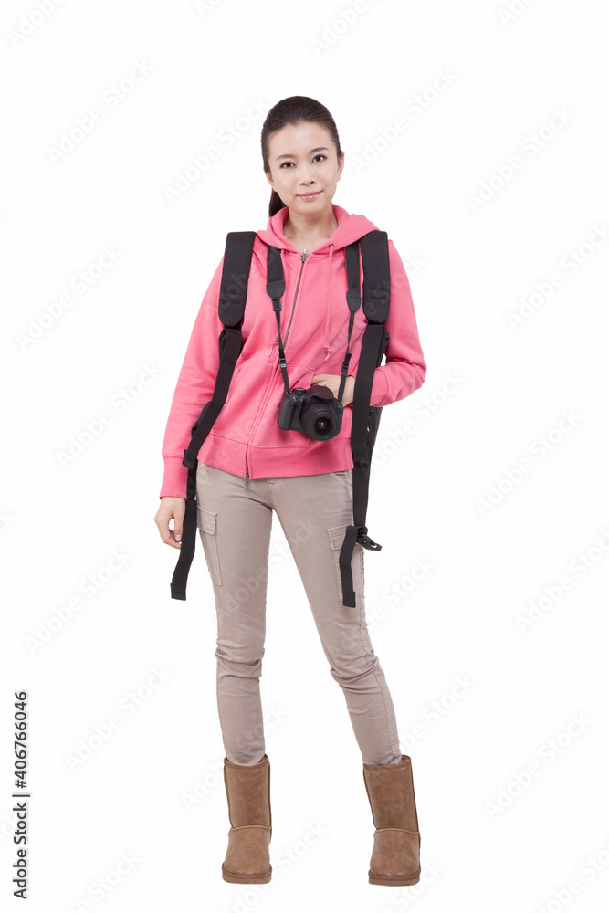 Fototapeta premium Portrait of young female carrying backpacker holding camera