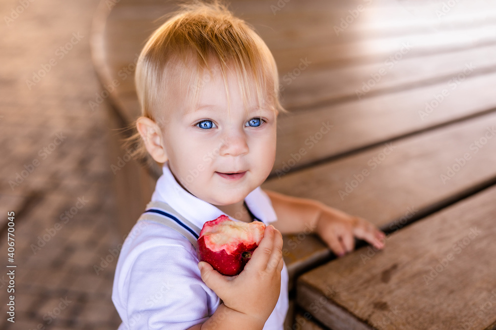 Cute smiling little schoolgirl holding a hamburger and orange juice outdoor - Back to school Cute smiling little schoolgirl holding a hamburger and orange juice outdoor - Back to school