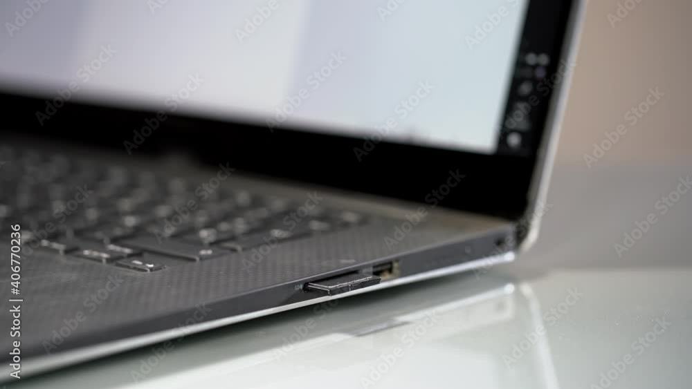 Hand inserting sd card into laptop integrated card reader Hand inserting sd card into laptop integrated card reader