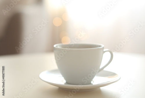 Cup of aromatic coffee on table indoors. Bokeh effect