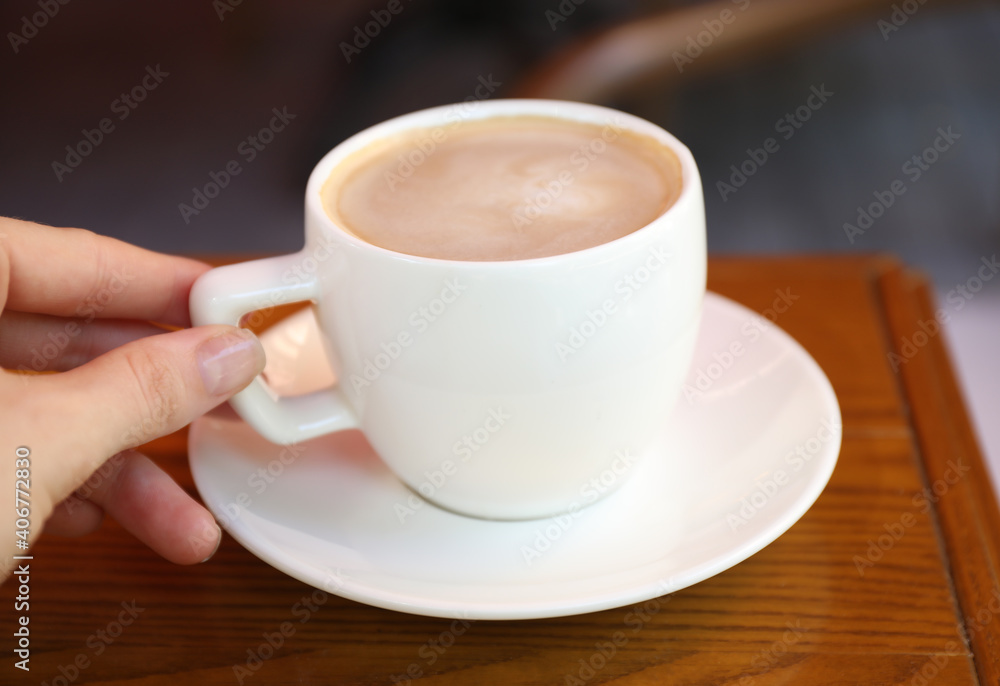 Woman drinking aromatic coffee in cafe outdoors, closeup