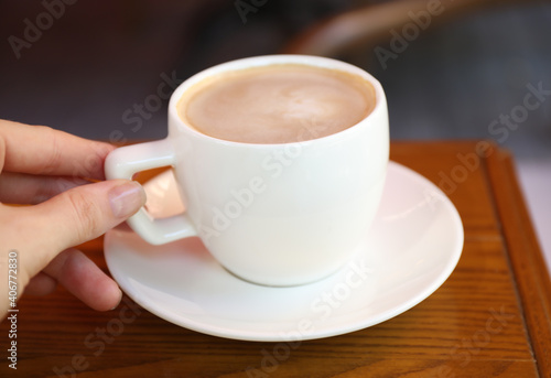 Woman drinking aromatic coffee in cafe outdoors, closeup