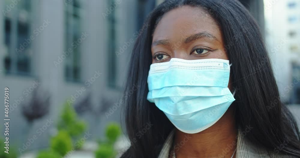 Close up of beautiful female scientist wearing protective mask against virus. Afrrican american woman with medical mask in public post covid space looking in camera. Safety after pandemic concept Close up of beautiful female scientist wearing protective mask against virus. Afrrican american woman with medical mask in public post covid space looking in camera. Safety after pandemic concept