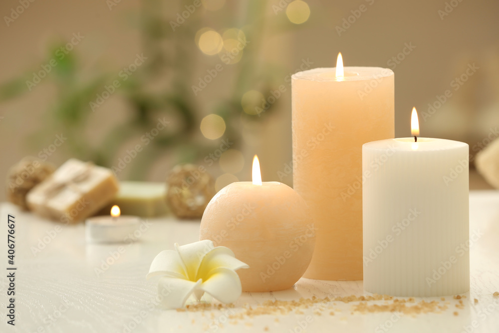 Burning candles on white table indoors. Space for text Burning candles on white table indoors. Space for text