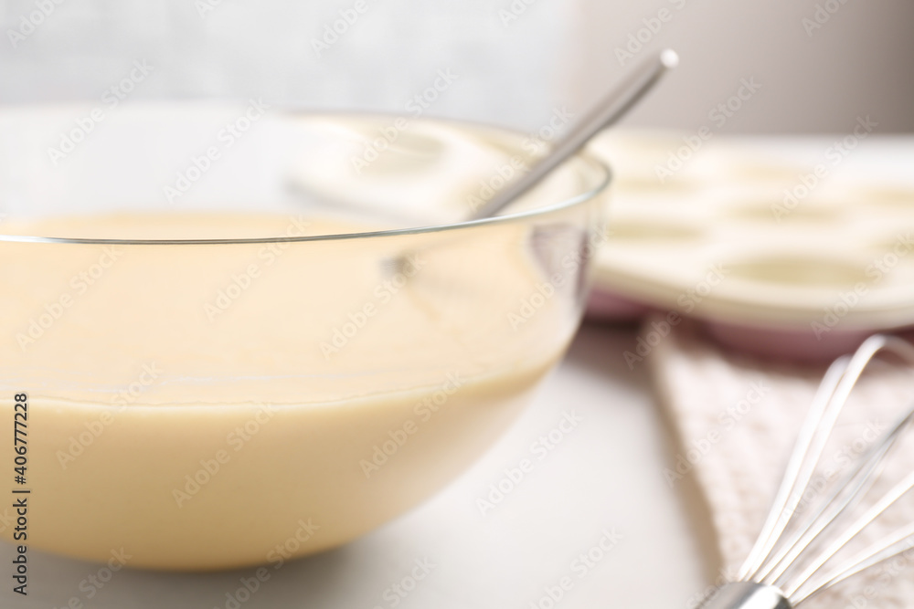 Glass bowl with batter on light table, closeup Glass bowl with batter on light table, closeup