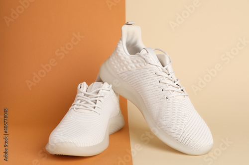 Pair of stylish sport shoes on color background