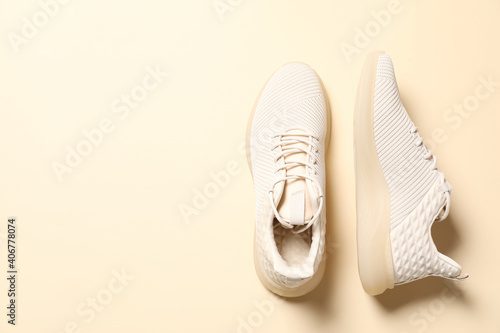 Pair of stylish sport shoes on beige background, flat lay. Space for text