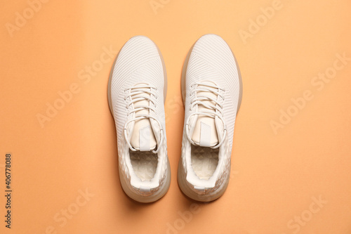 Pair of stylish sport shoes on orange background, flat lay