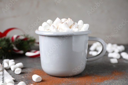 Cup of tasty hot drink with marshmallows on grey table