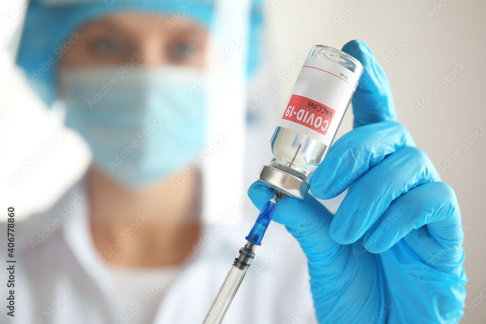 Doctor filling syringe with vaccine against Covid-19, closeup. Space for text Doctor filling syringe with vaccine against Covid-19, closeup. Space for text