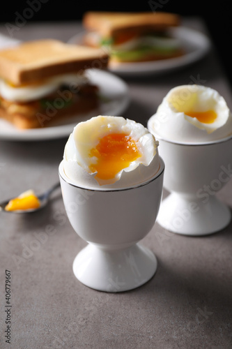 Soft boiled eggs served for breakfast on grey table, closeup