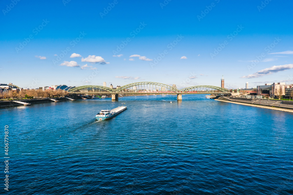 Cologne Koln Köln, Germany, Panorama view of the Rhine River with Hohenzollernbrücke, Cargo Ship and Blue Sky
