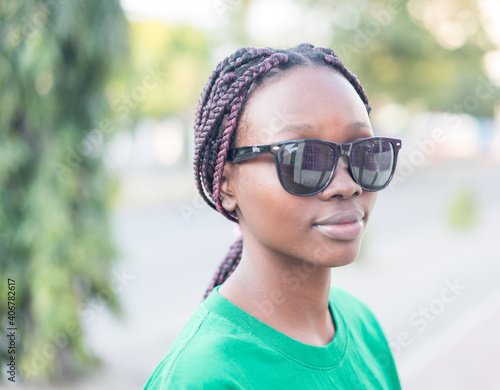 Young beautiful black girl using smart phone on sea at sunset