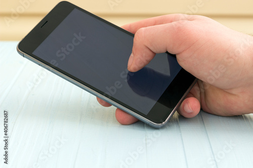 copy spaсe, the phone is in the hand on the background of the table, white screen	