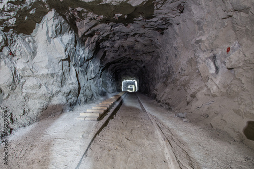 Underground gold mine shaft tunnel drift with rails and light