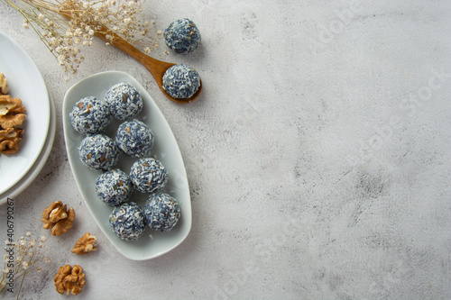 Energy bites made with blue spirulina powder, nuts, dried fruits and coconut flakes. Top view with copy space. photo