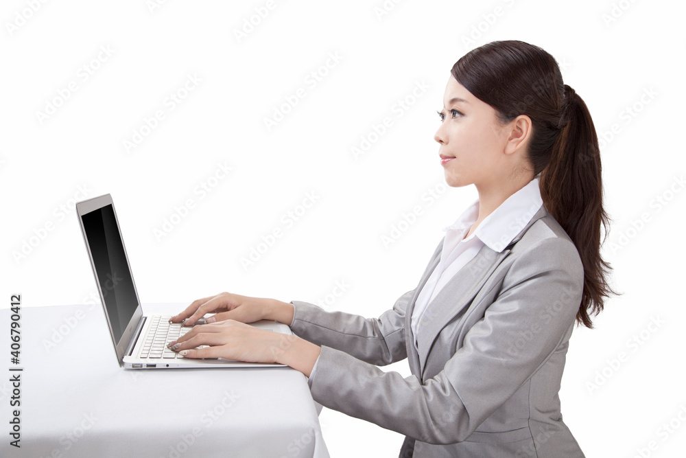 Portrait of young businesswoman sitting in front of laptop,side view Portrait of young businesswoman sitting in front of laptop,side view