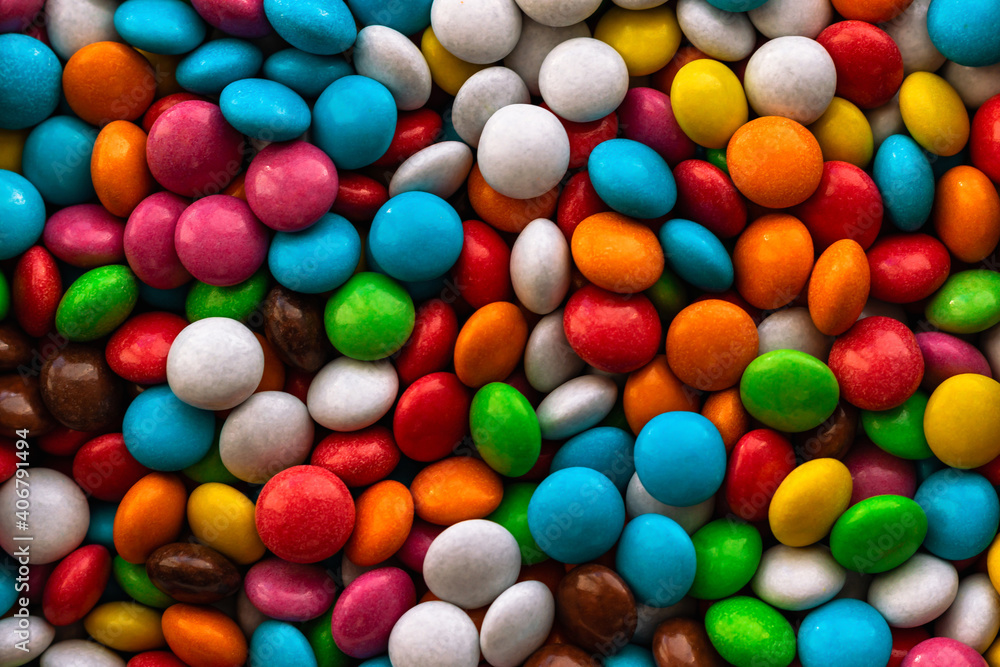 Background from a large number of multicolored sweets. Colorful set of flat sweets. Mix of colored sweets. Dragee sweets. Confectionery. Background from a large number of multicolored sweets. Colorful set of flat sweets. Mix of colored sweets. Dragee sweets. Confectionery.