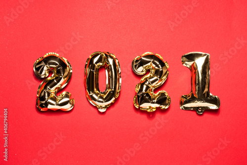 Gold Christmas balloons 2021 on a red background. Chinese New Year numbers. Flat lay and top view, template for copy space