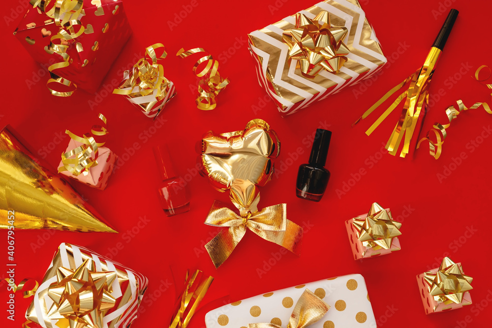 Red and black nail Polish, a gold balloon in the shape of a heart among the gifts on a red background
