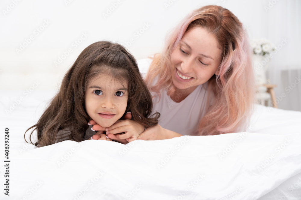 mother play with little active daughter in bed at home, having fun, activity with children mother play with little active daughter in bed at home, having fun, activity with children