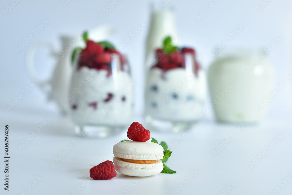 White vanilla macaroon closeup with mint leave and Raspberries on white background.two glasses of delicious homemade smoothie, dessert made from chia and berries. Healthy food and breakfast. White vanilla macaroon closeup with mint leave and Raspberries on white background.two glasses of delicious homemade smoothie, dessert made from chia and berries. Healthy food and breakfast.