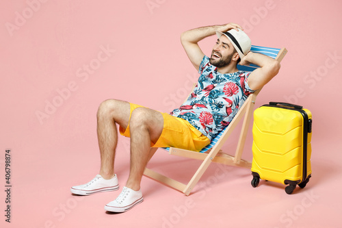 Fotobehang Full length of funny young traveler tourist man in summer clothes hat sit on deck chair put hands on head isolated on pink background
