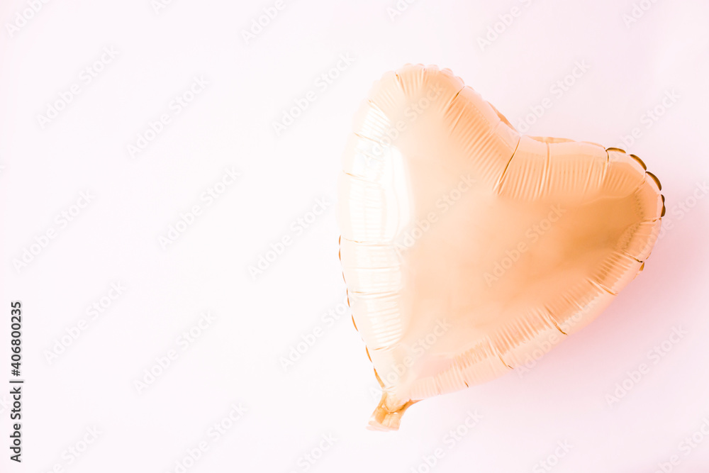 Fototapeta premium a ball of gold foil on a yellow background. Valentine's Day. The heart.