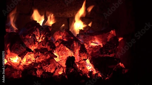 Fire and embers from burned wood in fireplace.