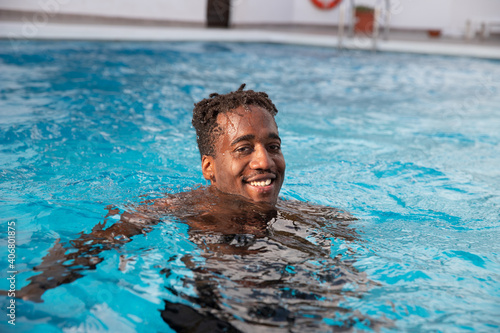 Black boy enjoys the swimming pool during his vacation © Media Lens King