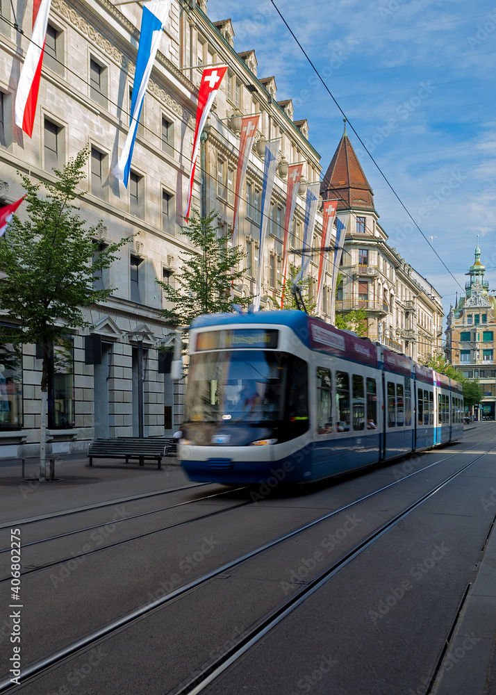 A blue tram traveling along an iconic shopping street in Zurich, Switerland