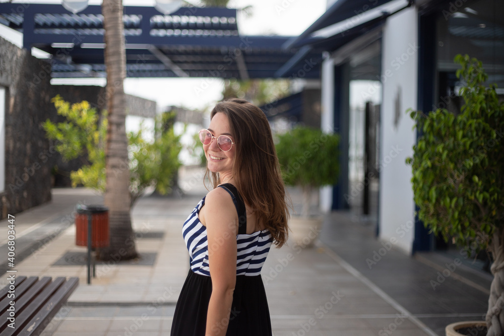 Attractive stylish caucasian girl is very happy and smiles because she is on vacation in an exotic location Attractive stylish caucasian girl is very happy and smiles because she is on vacation in an exotic location