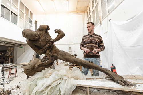 Sculptor in his workshop creating a sculpture photo
