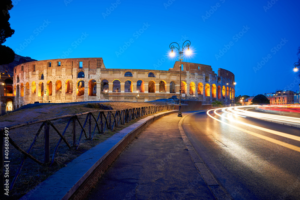 Lischtspuren bei Nacht mit dem Kolosseum in Rom, Italien. Aufnahme in der blauen Stunde.