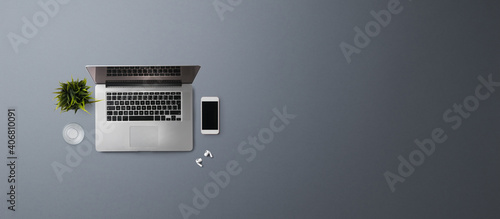 Flat lay top view office desk working space with laptop on gray background. Copy space.