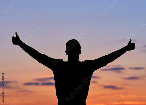 Men silhouette at sunset, human body over natural colorful sky background, hands up having fun